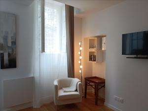 昂热Villa Buffon的客厅配有白色椅子和电视