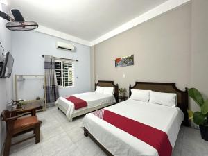 岘港OYO 1187 Suoi Da Motel的一间酒店客房,设有两张床和电视