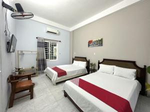 岘港OYO 1187 Suoi Da Motel的酒店客房设有两张床和电视。