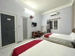岘港OYO 1187 Suoi Da Motel的一间卧室设有两张床和滑动玻璃门