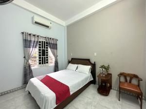 岘港OYO 1187 Suoi Da Motel的一间卧室设有一张床、一个窗口和一把椅子