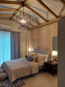 大雅台Alpine Breeze at Crosswinds Tagaytay的一间卧室配有一张大床和一个吊灯。