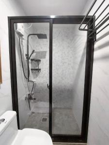 大雅台Alpine Breeze at Crosswinds Tagaytay的一间带卫生间的浴室内的玻璃淋浴间