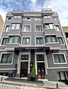 伊斯坦布尔Novus Hotel İstanbul的一座大型灰色建筑,上面有标志