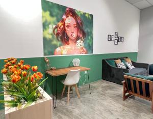 怡保Studio S Conceptual Homestay Station 18 - Ipoh的一间房间,配有一张桌子和一幅女人的画