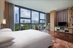 深圳深圳欢乐海岸万豪行政公寓的卧室设有一张白色大床和大窗户