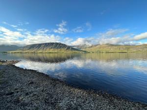 莫斯费德斯拜尔Cosy lakeview cabin 45 minutes from Reykjavik的山在水体中反射