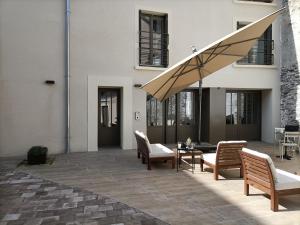 昂热Villa Buffon的庭院配有桌椅和遮阳伞。