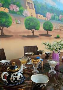 希瓦Khiva Khan Hotel的一张桌子,上面有盘子和碗,上面有绘画