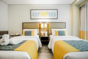 长滩岛Belmont Hotel Boracay的酒店客房带两张带黄床单的床