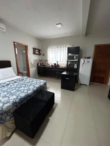 乌鲁比西Casa Copacabana 2的一间卧室配有一张床,厨房配有冰箱