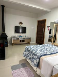 乌鲁比西Casa Copacabana 2的一间卧室配有一张床和一台平面电视