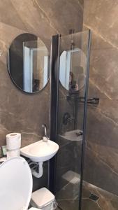 内坦亚普雷格海滩Q村酒店的一间带卫生间、水槽和镜子的浴室
