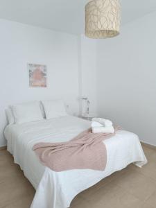 赫雷斯-德拉弗龙特拉SHERRY SUITES VIII Apartamentos PARKING GRATUITO的白色的卧室,床上有毯子