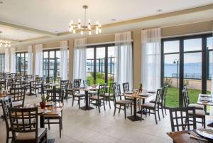 马蒂Ramada by Wyndham , Athens Club Attica Riviera的用餐室设有桌椅和窗户。