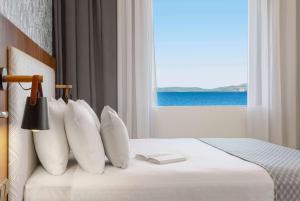 马蒂Ramada by Wyndham , Athens Club Attica Riviera的一间卧室设有一张床,享有海景