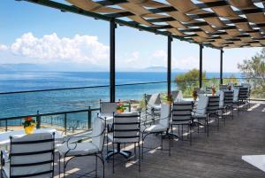 马蒂Ramada by Wyndham , Athens Club Attica Riviera的甲板上一排椅子和桌子,享有海景