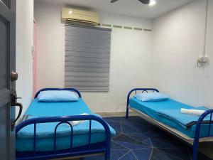 关丹Hs Homestay Cenderawasih Kuantan Town (5 Bed)的一间医院的两张床,设有窗户
