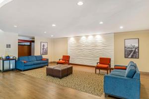 里士满弗吉尼亚中心康芒斯康福特套房酒店的大堂设有2张蓝色的沙发和2把红色的椅子