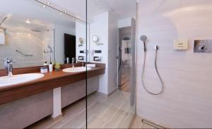 不莱梅ATLANTIC Hotel Landgut Horn的一间带两个盥洗盆和淋浴的浴室