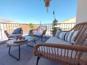 卡利诺岛Ammoudara's apartments Rooftop的阳台配有沙发和桌椅。