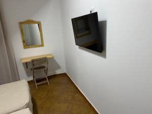 麦德林里约旅馆的一间墙上配有电视的房间,配有桌子