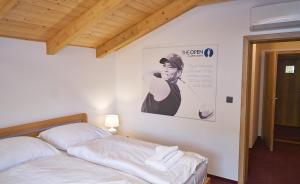 波胡达聂芝温泉城Golf Resort Lázně Bohdaneč的卧室配有一张床,墙上挂着一张女人的照片