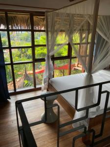阿姆巴托洛阿卡Moemoea Lodge的一间卧室配有一张床和一张玻璃桌