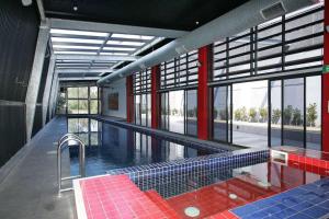 墨尔本Urban Uptown: Stylish Richmond的一座大型游泳池,在建筑中铺有红色和蓝色瓷砖