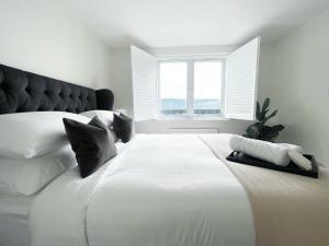 布莱顿霍夫Stunning modern space with harbour views & free parking的卧室内的一张大白色床,带有窗户