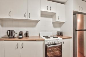 悉尼3 Bedrooms - Darling Harbour - Glebe St 2 E-Bikes Included的厨房配有白色橱柜和炉灶。
