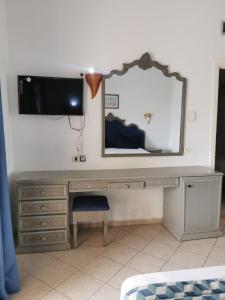 米多恩Hotel Diar Yassine的一张带镜子的桌子和墙上的电视