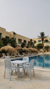 米多恩Hotel Diar Yassine的游泳池旁的桌椅