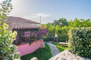 阿列恩图Casa Baia Vignola的一个带围栏的后院和一个种有鲜花的花园