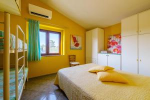 阿列恩图Casa Baia Vignola的卧室拥有黄色的墙壁,设有一张床和窗户。