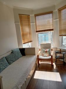 普里茅斯Ocean City Apartment-with parking的带沙发、椅子和窗户的客厅