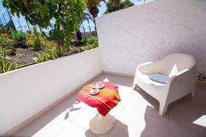 德尔锡伦西奥海岸Chaparal Design Apartment的阳台的白色椅子和桌子