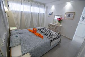 德尔锡伦西奥海岸Chaparal Design Apartment的一间卧室配有一张带橙色玩具的床