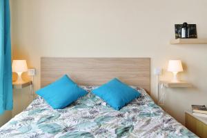 埃尔戈尔福Viviendas El Pescador - Timón的一间卧室配有一张带两个蓝色枕头的床