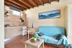 埃尔戈尔福Viviendas El Pescador - Timón的一间带蓝色沙发的客厅和一间厨房