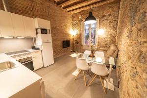 巴塞罗那巴塞罗那高迪公寓的厨房以及带桌椅的起居室。
