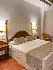 卡索拉Hotel Rural Cazorla Posada del Cordobés的卧室配有一张带两个枕头的大白色床