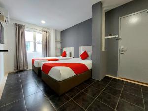马六甲Good2Stay Budget Hotel的酒店客房 - 带两张带红色枕头的床