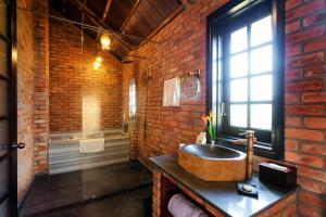 会安ENSO Retreat Hoi An的一间带石水槽和砖墙的浴室