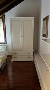 巴登-巴登花园公寓的卧室配有白色橱柜和1张床