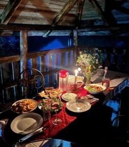 FierzëGuest House Aprripe Guri的餐桌,带食物盘和酒杯