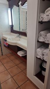 圣吕斯studio village vacance sainte luce C5的浴室配有盥洗盆、镜子和毛巾