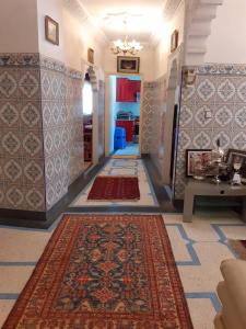 El Kelaa des SrarhnaBel Appartement à El kelaa Des Srarhna的墙上有彩色地毯的走廊和走廊