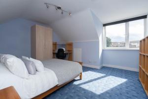 阿伯丁Dwellcome Home Ltd 3 Double Bedroom Semi with Garden and Drive的卧室配有带白色枕头的床和窗户。