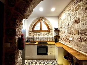 阿卡Suzanne Suite的厨房设有石墙和窗户。
